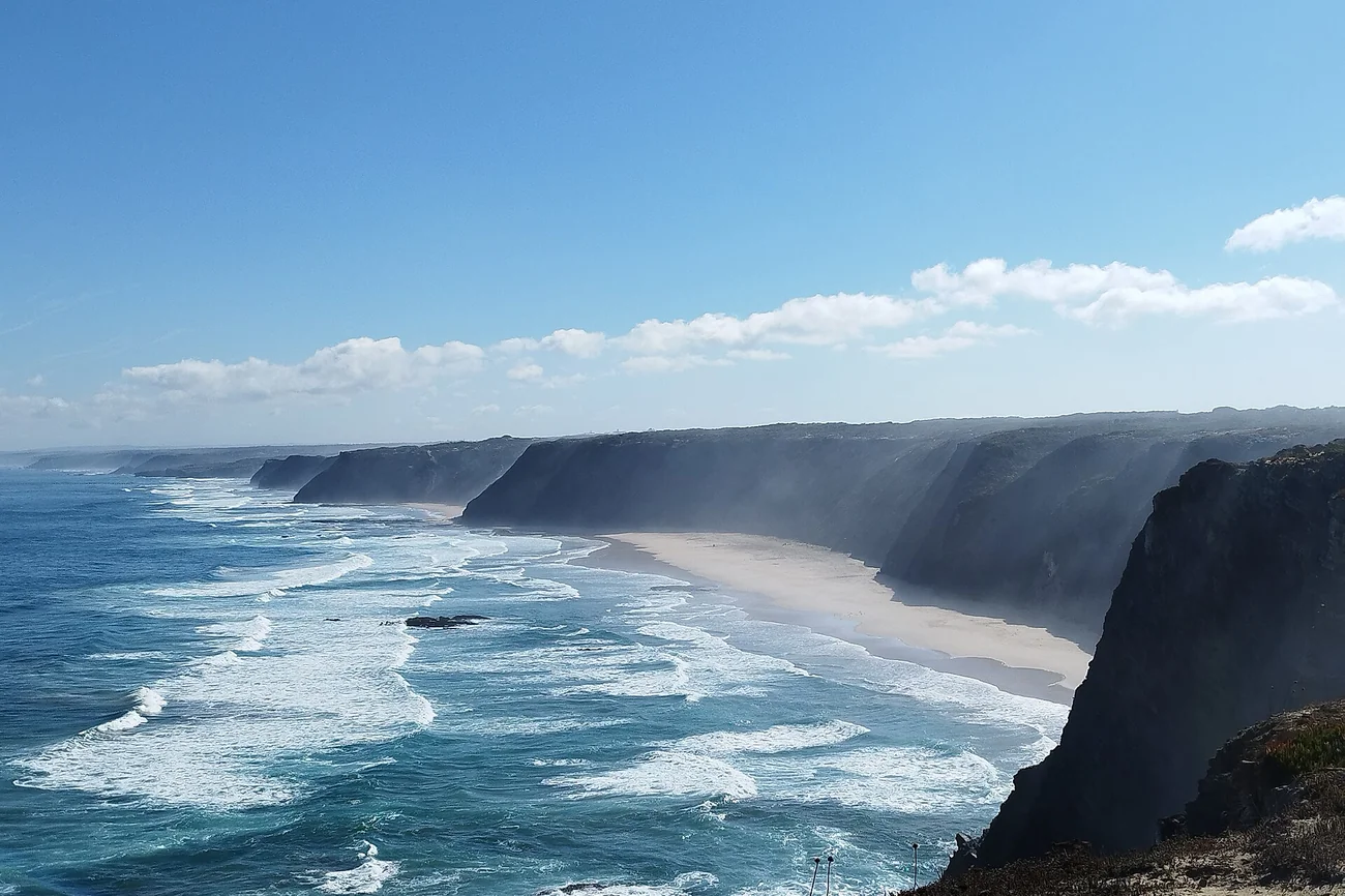 High dark cliffs and a long sandy beach at Ponta da Atalaia on the Atlantic coast near Aljezur