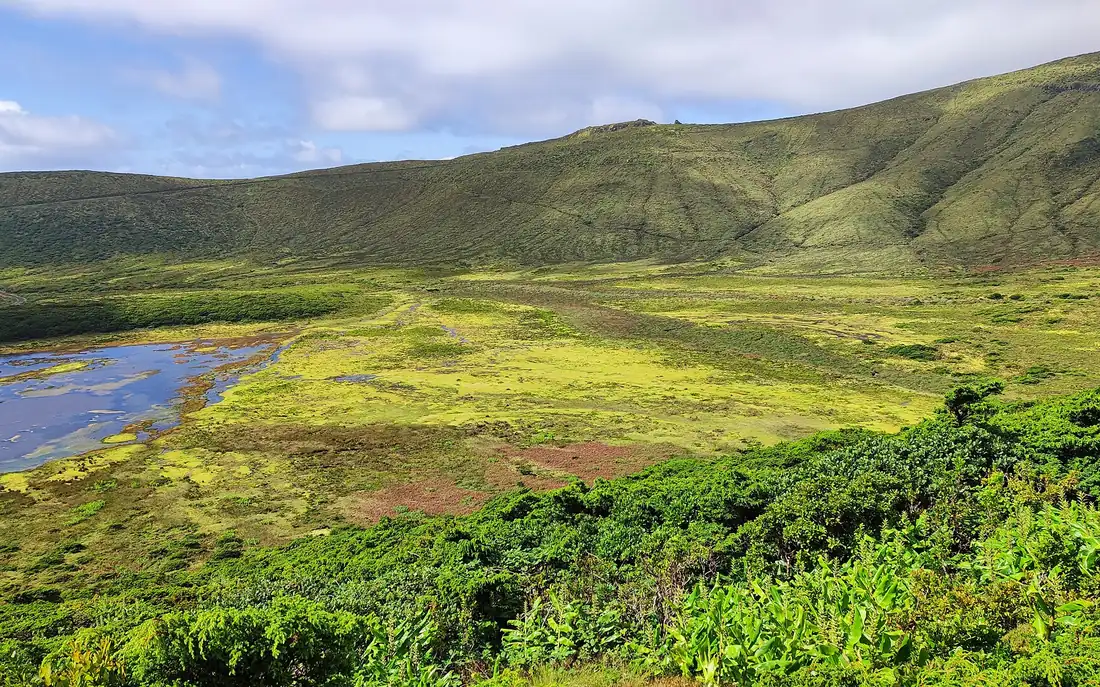 A green crater valley with a small lake on Flores island in the Azores